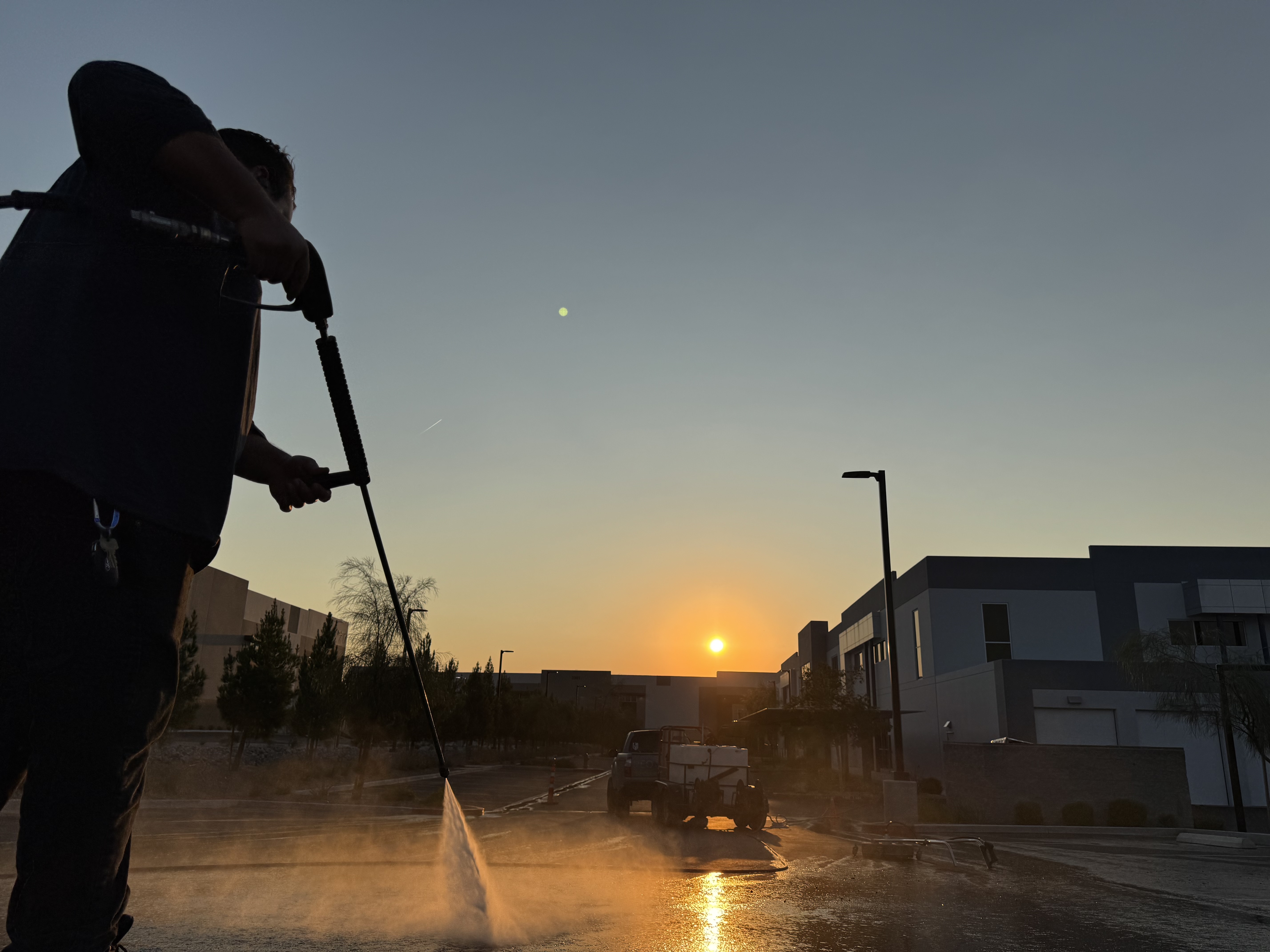Neon Window Cleaning technician pressure washing a paved stone tile driveway on a Las Vegas residential property