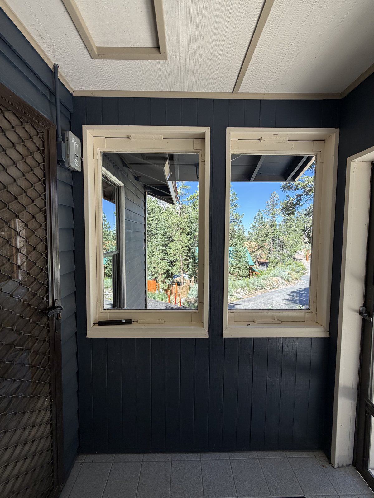 The same Mt. Charleston cabin porch windows crystal clear after professional cleaning, with pine forest views restored